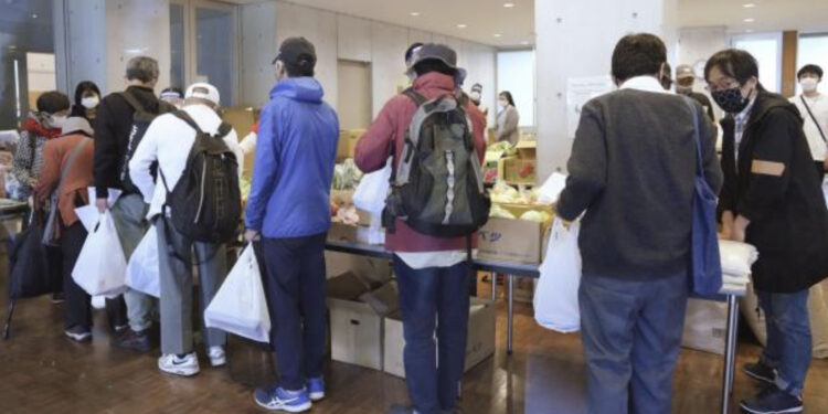 Diante da crise, 200 pessoas se reúnem para receber alimentos em igreja de Tóquio. Foto: Kyodo News