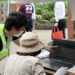 Estudante orienta uma idosa durante evento sobre crimes cibernéticos em Saitama. Reprodução/Jornal Asahi.
