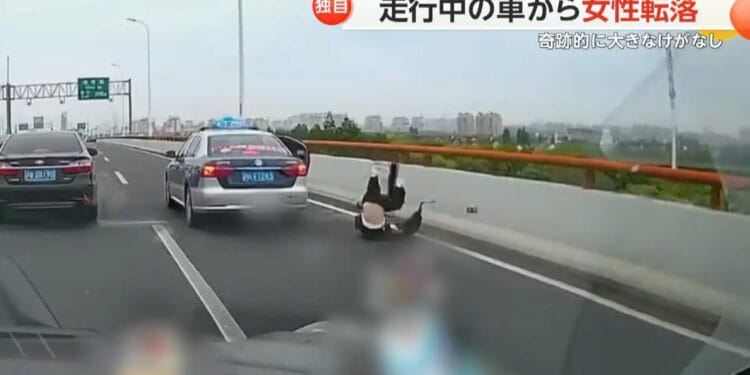 xangai-taxi - ThingsOut Imagem mostra o momento que a passageira pulou do carro em movimento. Reprodução / FNN.