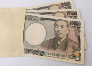 Several 10,000 yen banknotes partially tucked into a light brown envelope.