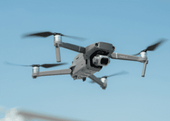 Drones com sons de cães são usados para espantar animais selvagens em Niigata - ThingsOut Drone in midair: a gray Mavic 2 quadcopter with forward-facing camera against a blue sky, propellers blurred from motion.