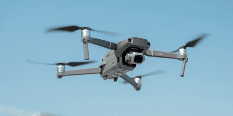 Drones com sons de cães são usados para espantar animais selvagens em Niigata - ThingsOut Drone in midair: a gray Mavic 2 quadcopter with forward-facing camera against a blue sky, propellers blurred from motion.