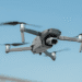 Drones com sons de cães são usados para espantar animais selvagens em Niigata - ThingsOut Drone in midair: a gray Mavic 2 quadcopter with forward-facing camera against a blue sky, propellers blurred from motion.