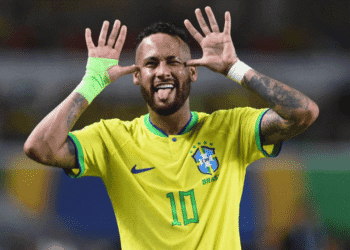 Neymar é convocado por Ancelotti e disputará sua quarta Copa do Mundo com o Brasil - ThingsOut Brazilian soccer player wearing a yellow Brazil jersey with number 10, hands to ears, tongue out in celebration.