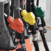 Preço médio da gasolina no Japão segue abaixo de ¥170 com apoio de subsídios - ThingsOut Close-up of several fuel nozzle handles in red, yellow, and green at a gas pump station.