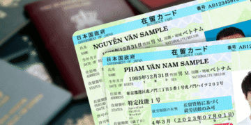 Renovação de visto e residência permanente ficarão mais caras no Japão - ThingsOut Two overlapping Japanese residence cards at an angle, labeled SAMPLE, showing photos and personal details (names, birth dates).