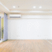 Fukuoka propõe subsídio para ar-condicionado e geladeira com foco em eficiência energética - ThingsOut Bright empty living room with wood floor, white walls, recessed lighting, and a sliding glass door with purple curtains.
