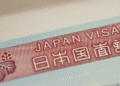 Close-up of a red Japan visa label with the text 'JAPAN VISA' and Japanese characters on a light blue border.