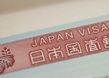 Close-up of a red Japan visa label with the text 'JAPAN VISA' and Japanese characters on a light blue border.