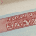 Close-up of a red Japan visa label with the text 'JAPAN VISA' and Japanese characters on a light blue border.