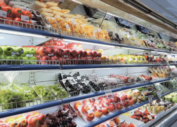 Mais de 1000 alimentos terão aumento de preço no Japão em junho - ThingsOut Rows of pre-cut fruit and fresh produce in a supermarket refrigerated display case, organized by type and color