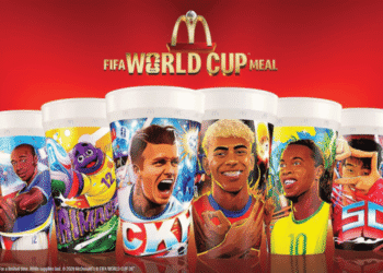 Limited edition McDonald's FIFA World Cup Meal cups featuring illustrated football players against a red backdrop, promoting a busy promo rail.