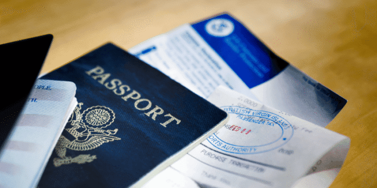 Novas restrições a estrangeiros podem prejudicar a imagem global do Japão - ThingsOut Blue US passport with embossed seal on a wooden table beside travel documents and tickets.