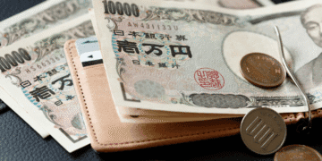 Governador de Aichi pede aumento maior do salário mínimo e pressiona debate sobre custo de vida - ThingsOut Japanese yen banknotes and coins resting on a brown wallet, money and currency concept (10,000 yen notes)