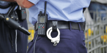 Idoso em Fukui perde ¥60 milhões em golpe com falso policial e alerta cresce no Japão - ThingsOut Police officer's waist area with a radio and handcuffs clipped to the belt