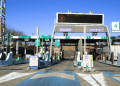 Japão abre campanha para instalar ETC com desconto de até ¥10 mil mas há regras e prazo curto - ThingsOut Highway toll plaza in Japan with multiple ETC lanes and green signs; digital board overhead and a 20 km/h speed limit sign visible in the foreground.