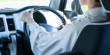 Japão endurece punições para direção perigosa e define critérios objetivos para embriaguez e alta velocidade - ThingsOut Person driving a car, hands on the steering wheel, dashboard and interior visible from the passenger side window behind the driver