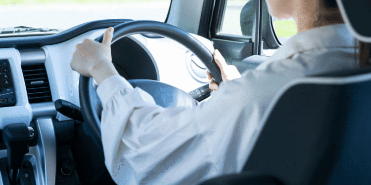Japão endurece punições para direção perigosa e define critérios objetivos para embriaguez e alta velocidade - ThingsOut Person driving a car, hands on the steering wheel, dashboard and interior visible from the passenger side window behind the driver