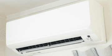 Japão prevê queda nas contas de luz e gás em agosto com reforço de subsídios - ThingsOut White wall-mounted air conditioner unit with its front panel closed and vent opening visible on the lower front edge.