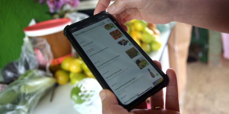 Consumidora utiliza aplicativo de compras em Piedade (SP)