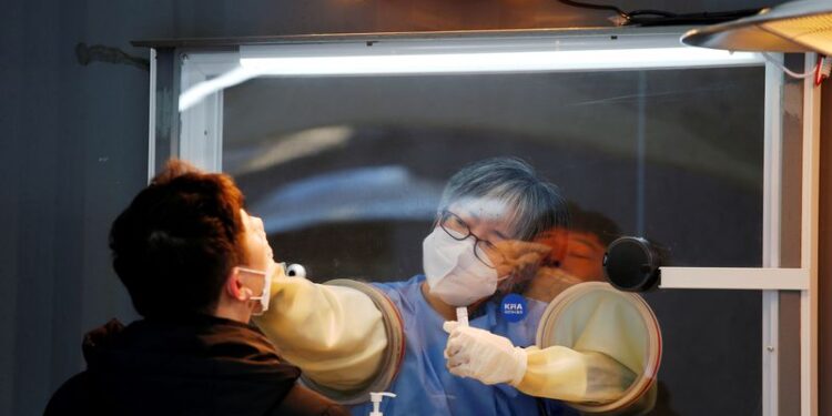 FILE PHOTO: A man undergoes the coronavirus disease (COVID-19) test at a testing site at City Hall Plaza in Seoul