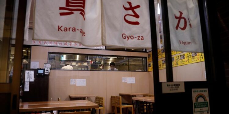 Vegan izakaya restaurant Masaka's manager Yuta Namekawa works in the kitchen as the restaurant is empty during the dinner hour in Tokyo