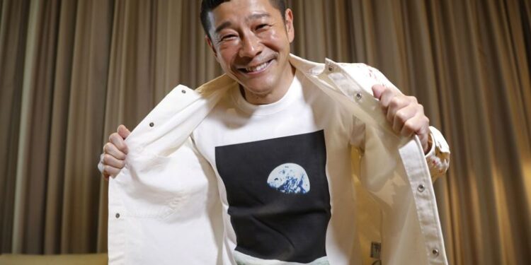 Japanese billionaire Yusaku Maezawa poses with his T-shirt bearing an image of Earth during an interview with Reuters in Tokyo